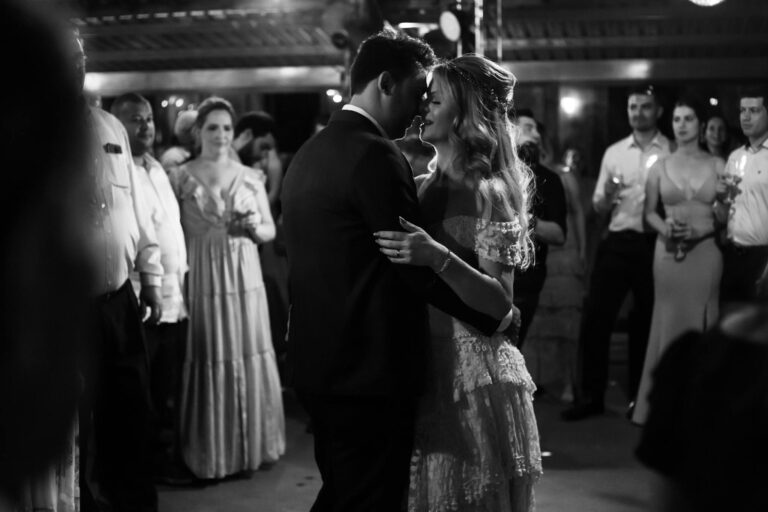 A black and white photo captures a couple's romantic first dance at a wedding reception.