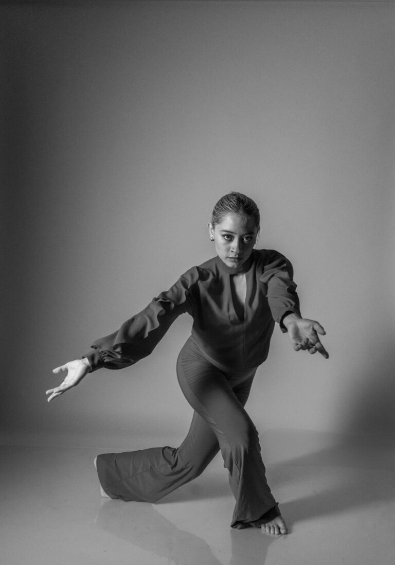 Striking black and white image of a contemporary dancer in motion indoors.